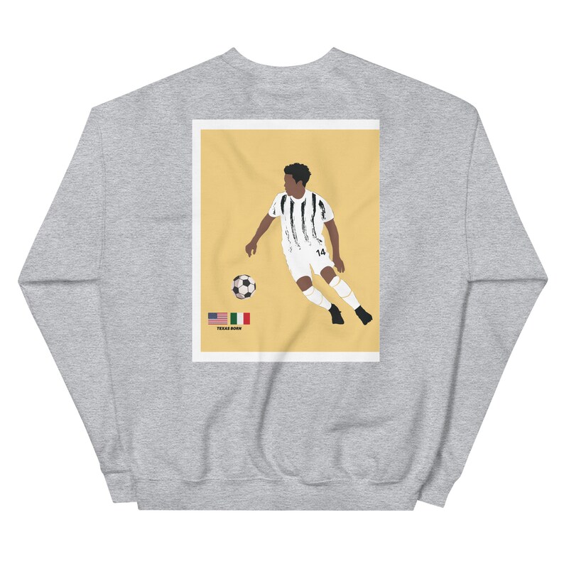 May include: A gray sweatshirt with a yellow background image of a soccer player in a white and black jersey with the number 14 on the back. The player is kicking a soccer ball. The image also includes the text "TEXAS BORN" and the flags of the United States and Italy.