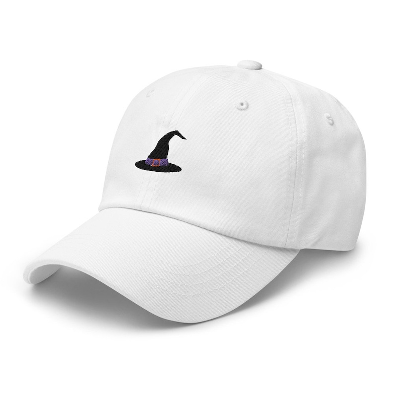 May include: White baseball cap with a black embroidered witch hat with a purple and orange band.