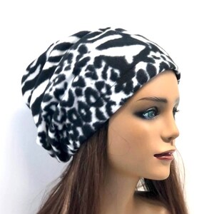 May include: A black and white zebra print fleece beanie hat. The hat is soft and warm, perfect for cold weather.