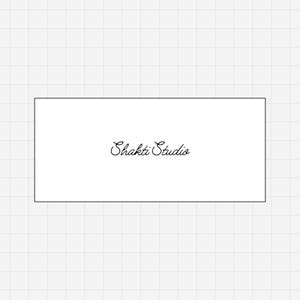 Pode incluir: Uma etiqueta retangular branca com uma borda preta fina apresentando o texto Shakti Studio escrito em uma fonte cursiva preta, centralizado na etiqueta contra um fundo de padr&atilde;o de grade cinza claro.