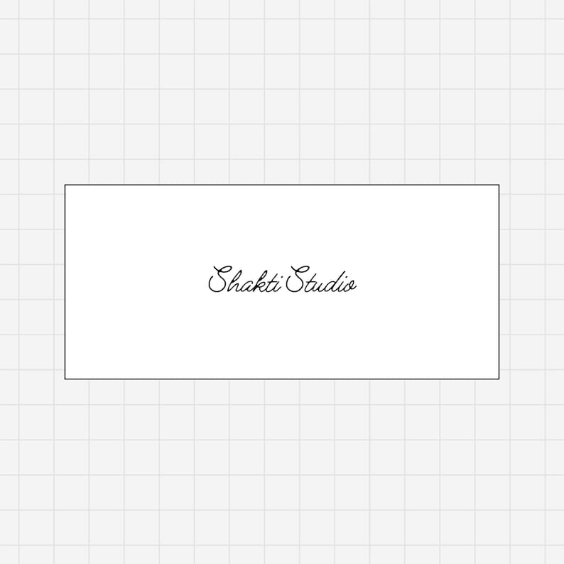 May include: A white rectangular card with the words "Shakti Studio" written in elegant cursive script. The text is centered on the card, which is set against a light gray grid background. The overall design is simple and clean.