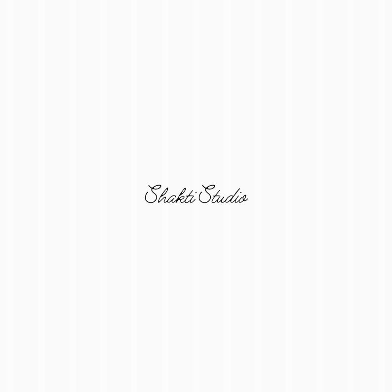 May include: The image features the text "Shakti Studio" in elegant cursive script. The text is in black and is centered on a white background with subtle vertical stripes, creating a clean and minimalist aesthetic.