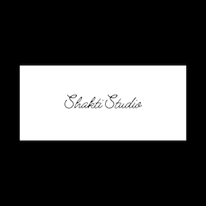 Puede incluir: Un gr&aacute;fico rectangular blanco con las palabras "Shakti Studio" en una elegante escritura negra cursiva. El texto est&aacute; centrado en el fondo blanco, sobre un fondo negro s&oacute;lido.