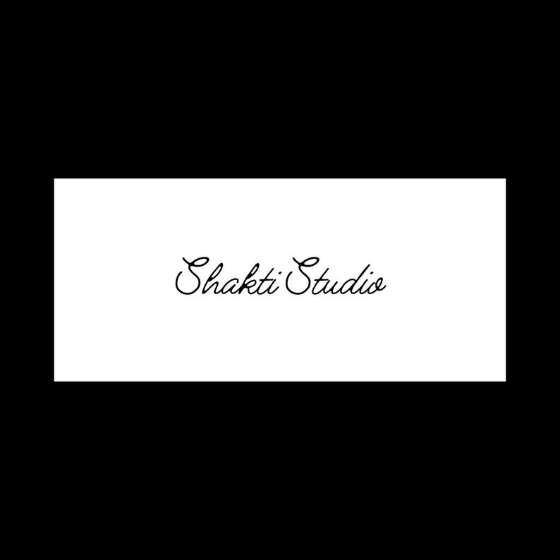 Puede incluir: Un gr&aacute;fico rectangular blanco con las palabras "Shakti Studio" en una elegante escritura negra cursiva. El texto est&aacute; centrado en el fondo blanco, sobre un fondo negro s&oacute;lido.