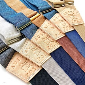 Custom handmade suspenders in black, gray, navy, burnt orange, French blue, and tan with personalized leather back patches. Perfect for weddings, groomsmen, and classic menswear. Ethically made with premium materials by Stratton Suspender Co.