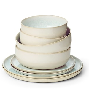 May include: A stack of four light blue and cream ceramic bowls with a light blue and cream ceramic plate underneath.