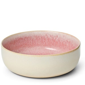 Op de afbeelding: Een grote, ronde, keramische serveerschaal met een witte basis en een roze ombre-glazuur. De schaal is perfect om salades, pasta of fruit te serveren.