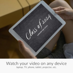 May include: A white tablet with a black screen displaying the text "Class of 2024 Lakeside High School". The text is written in white chalk on a black chalkboard background. The tablet is being held by a person's hands.