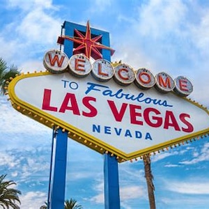 May include: A classic Las Vegas welcome sign with a blue and yellow diamond-shaped frame. The sign reads "Welcome to Fabulous Las Vegas, Nevada".