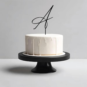Adorno para tarta de bodas con letras iniciales en blanco y negro minimalistas y cursivas modernas