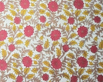 Op de afbeelding: Een bloemenpatroon met roze bloemen, gele bladeren en bruine wijnranken op een witte achtergrond. Het patroon is dicht en bedekt het hele oppervlak, waardoor een rijk textielontwerp ontstaat.