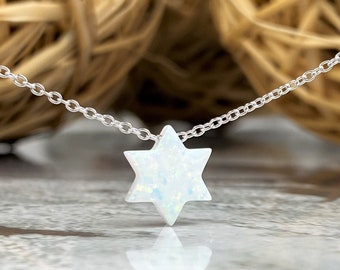 May include: A silver chain necklace with a white opal Star of David pendant.