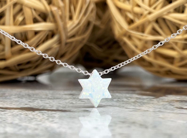 May include: A silver chain necklace with a white opal Star of David pendant.