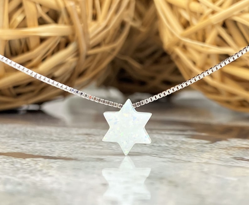 May include: A silver chain necklace with a white opal Star of David pendant.