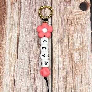 Llavero con nombre personalizable: cuentas de flores y letras de silicona, dorado.