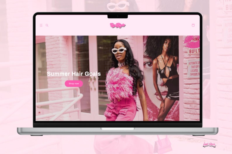 May include: A laptop computer displaying a website with a pink background and the text "Summer Hair Goals". The website features a photo of a person with long black hair wearing a pink outfit and sunglasses. The website also has a button that says "Shop Now".