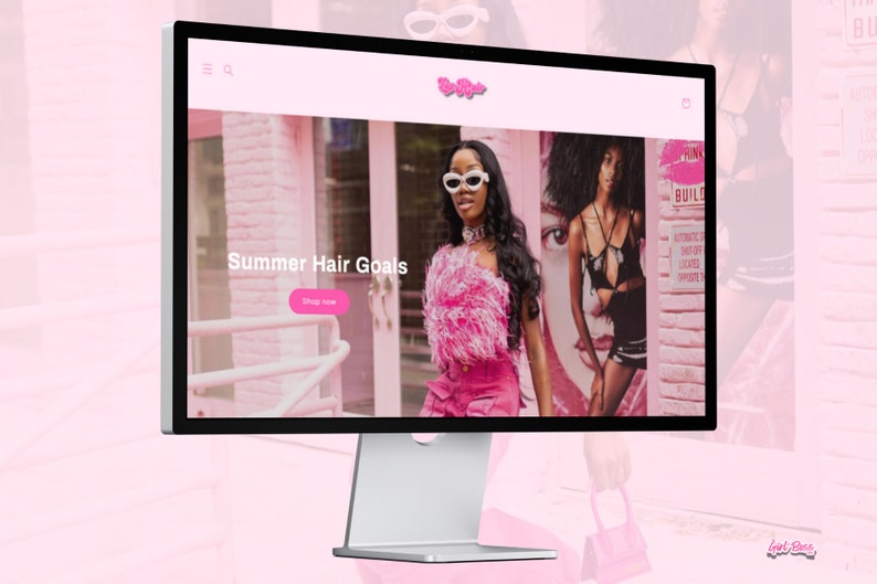 May include: A computer screen displaying a website with the text "Summer Hair Goals" and a pink button that says "Shop Now". The website features a model with long black hair wearing a pink feathered top and pink pants. The background is a pink brick wall.