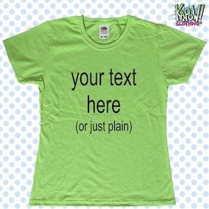 May include: A bright green t-shirt featuring the text "your text here (or just plain)" in black. The shirt has a round neck and short sleeves. The Kapow! Clothing logo is visible in the top right corner.
