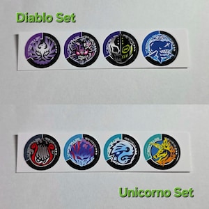 Pu&ograve; includere: Un foglio di adesivi con disegni circolari raffiguranti mostri e creature. La fila superiore &egrave; etichettata "Diablo Set" e quella inferiore "Unicorno Set". Ogni adesivo ha un design a codice a barre in bianco e nero.