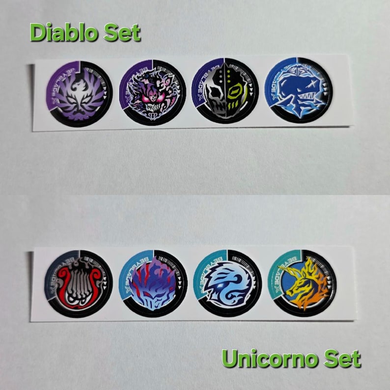 Pu&ograve; includere: Un foglio di adesivi con disegni circolari raffiguranti mostri e creature. La fila superiore &egrave; etichettata "Diablo Set" e quella inferiore "Unicorno Set". Ogni adesivo ha un design a codice a barre in bianco e nero.