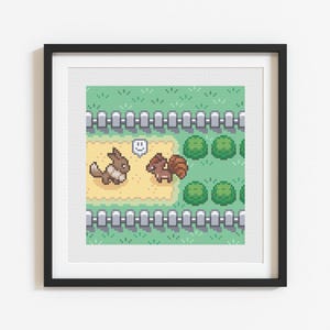 May include: Framed pixel art print featuring two cartoon animals in a grassy landscape with a fence and bushes. One animal has a speech bubble. The artwork is in a black frame and is displayed on a white wall.