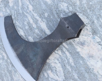 May include: A black metal axe with a curved blade and a handle with a hole in the top. The axe is on a gray and white marble surface.
