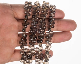 May include: A strand of faceted smoky quartz beads in various shades of brown. The beads are round and have a smooth, polished finish.