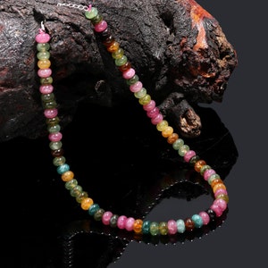 Könnte beinhalten: Eine mehrfarbige Edelstein-Halskette mit runden Perlen in Rosatönen, Grün und Gelb. Die Halskette besteht aus natürlichen Edelsteinen und ist auf einer silbernen Kette aufgefädelt.