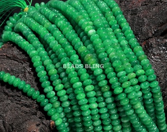 May include: A strand of bright green jade beads, each bead is round and slightly flattened, creating a smooth, polished look. The beads are strung together on a clear thread, and the strand is long enough to be used for making jewellery or other crafts.