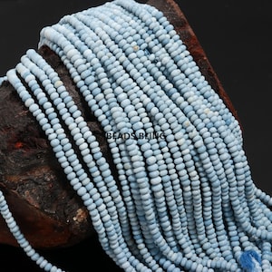 May include: A strand of light blue opal beads, approximately 4mm in size. The beads are round and smooth, and they have a slightly iridescent sheen.