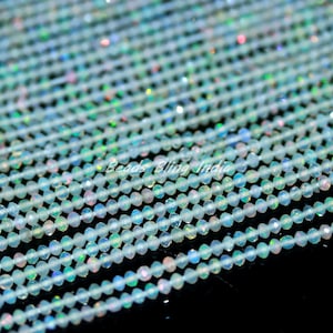 Puede incluir: Una hebra de cuentas de ópalo blanco iridiscente, cada cuenta es facetada y mide aproximadamente 4 mm de diámetro. Las cuentas están enhebradas en un hilo transparente y están listas para ser utilizadas en la elaboración de joyas.