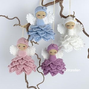 Pode incluir: Quatro enfeites de anjo de crochê feitos à mão em cores pastel: azul, branco, rosa e roxo. Cada anjo tem asas brancas, um pequeno chapéu e uma saia em forma de pétala. Estão suspensos em um galho contra um fundo branco.