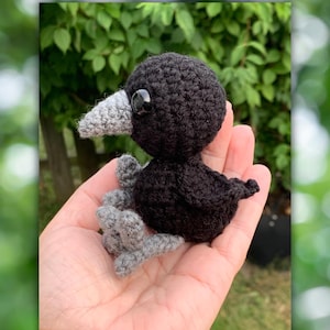 Op de afbeelding: Een klein zwart gehaakt vogeltje met grijze pootjes en een zwart oog. Het vogeltje zit in de palm van een hand.