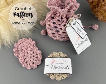 Könnte beinhalten: Eine Sammlung handgefertigter Häkelartikel in Rosa- und Beigetönen. Das Bild zeigt einen Kordelzugbeutel, zwei Untersetzer und einen Stapel Scrubbies, alle mit Etiketten mit der Aufschrift "Scrubbies" und "Crocheted by me". Der Text "Crochet pattern + Label & Tags" ist ebenfalls sichtbar.