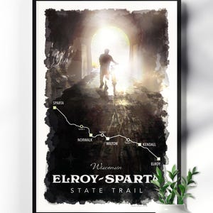 May include: Framed art print featuring a cyclist emerging from a tunnel, with a map of the Elroy-Sparta State Trail in Wisconsin. The print includes the trail's name and the towns of Sparta, Norwalk, Wilton, Kendall, and Elroy.