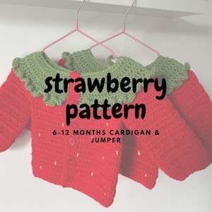 Peut inclure: Ensemble cardigan et pull pour bébé au crochet rouge et vert, en forme de fraise. L'ensemble comprend un col vert et de petits détails de graines blanches. Le texte "strawberry pattern" et "6-12 months cardigan & jumper" sont visibles.