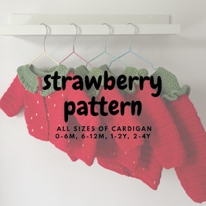 Peut inclure: Plusieurs cardigans rouges au motif de fraise crochetés, suspendus à une étagère blanche. Les cardigans ont des cols verts et des détails de points blancs. Le texte sur l'image indique "strawberry pattern" et "ALL SIZES OF CARDIGAN 0-6M, 6-12M, 1-2Y, 2-4Y."