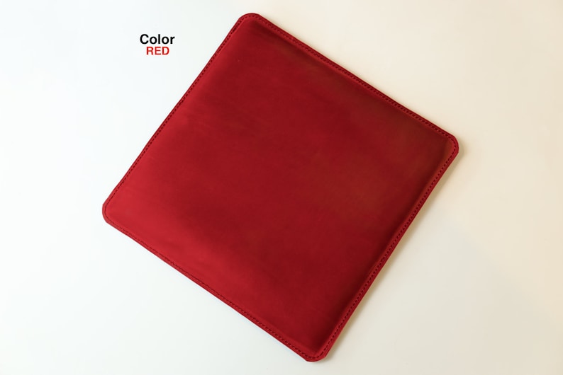May include: A red square-shaped cushion with a stitched edge.