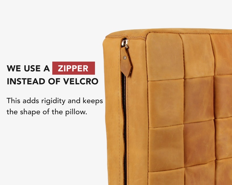 May include: A tan leather cushion featuring a square-stitched pattern and a metal zip closure on the side. The text on the image reads: WE USE A ZIPPER INSTEAD OF VELCRO. This adds rigidity and keeps the shape of the pillow.