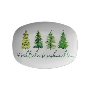 May include: White rectangular serving platter with four watercolor Christmas trees in varying shades of green. The words "Fr&ouml;hliche Weihnachten" are written in green script across the bottom. A festive holiday design.