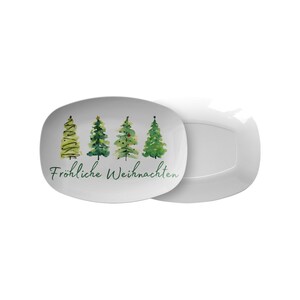 May include: White rectangular serving platter with a watercolor design of four green Christmas trees. The words "Fr&ouml;hliche Weihnachten" are written in green script below the trees. A second, identical platter is visible.