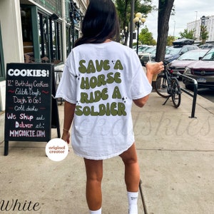 Back of shirt that says save a horse ride a solider in army green retro front outlined in black. Black stars in groups of 3 in various sizes in 4 random spots around words. For army girlfriends, army wives, and military spouses.