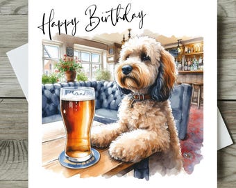 May include: A watercolor birthday card featuring a dog sitting at a pub table with a pint of beer. The words "Happy Birthday" are written in cursive at the top. The dog has brown and black fur and is wearing a collar.