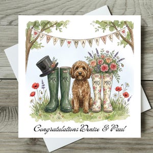 May include: A square greeting card featuring a watercolor illustration of a brown dog sitting between two pairs of rubber boots. One pair is green labeled MR with a top hat, the other is floral labeled MRS with flowers. A banner reads JUST MARRIED.