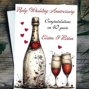 May include: A Ruby Wedding Anniversary card with a champagne bottle and two glasses filled with red liquid. The card includes the text "Ruby Wedding Anniversary", "Congratulations on 40 years", and the names "Elaine & Brian". Red heart accents are scattered around the image.
