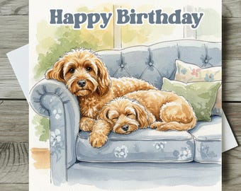 May include: Watercolor birthday card featuring two golden-brown dogs resting on a light blue sofa. The words "Happy Birthday" are written across the top in dark blue. Decorative pillows and a window are visible in the background.