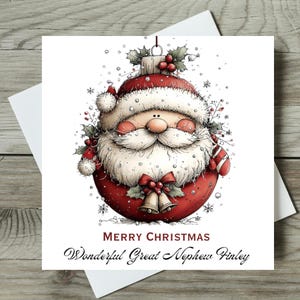 May include: A square greeting card featuring a round red Christmas ornament shaped like Santa Claus with a white beard, red hat, and holly berries. Below the illustration, the text reads MERRY CHRISTMAS Wonderful Great Nephew Finley.