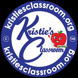 May include: A circular logo with a blue border and white interior. The text "kristiesclassroom.org" is in white around the border. The logo features a large blue "K" and "E" with the words "Kristie's classroom" in blue. A cartoon apple with a face and pointer is in the centre.