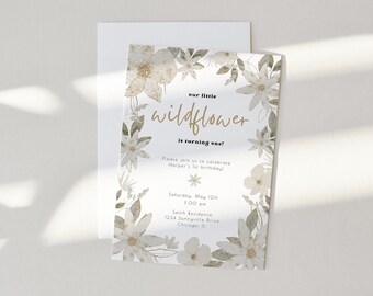 May include: A white and gold floral invitation card with the text "our little wildflower is turning one!"  Please join us as we celebrate [Name]'s 1st birthday. Saturday, May 12th, 1:00 pm, [Address], Chicago, IL.
