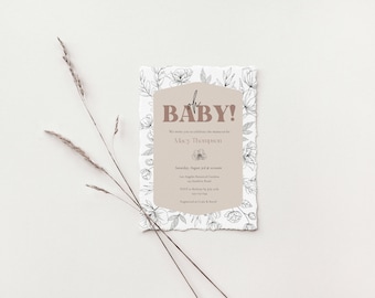 May include: A baby shower invitation with a floral design. The invitation is printed on textured paper and has a brown background. The text on the invitation reads "oh BABY!" and includes the name "Alex Thompson".